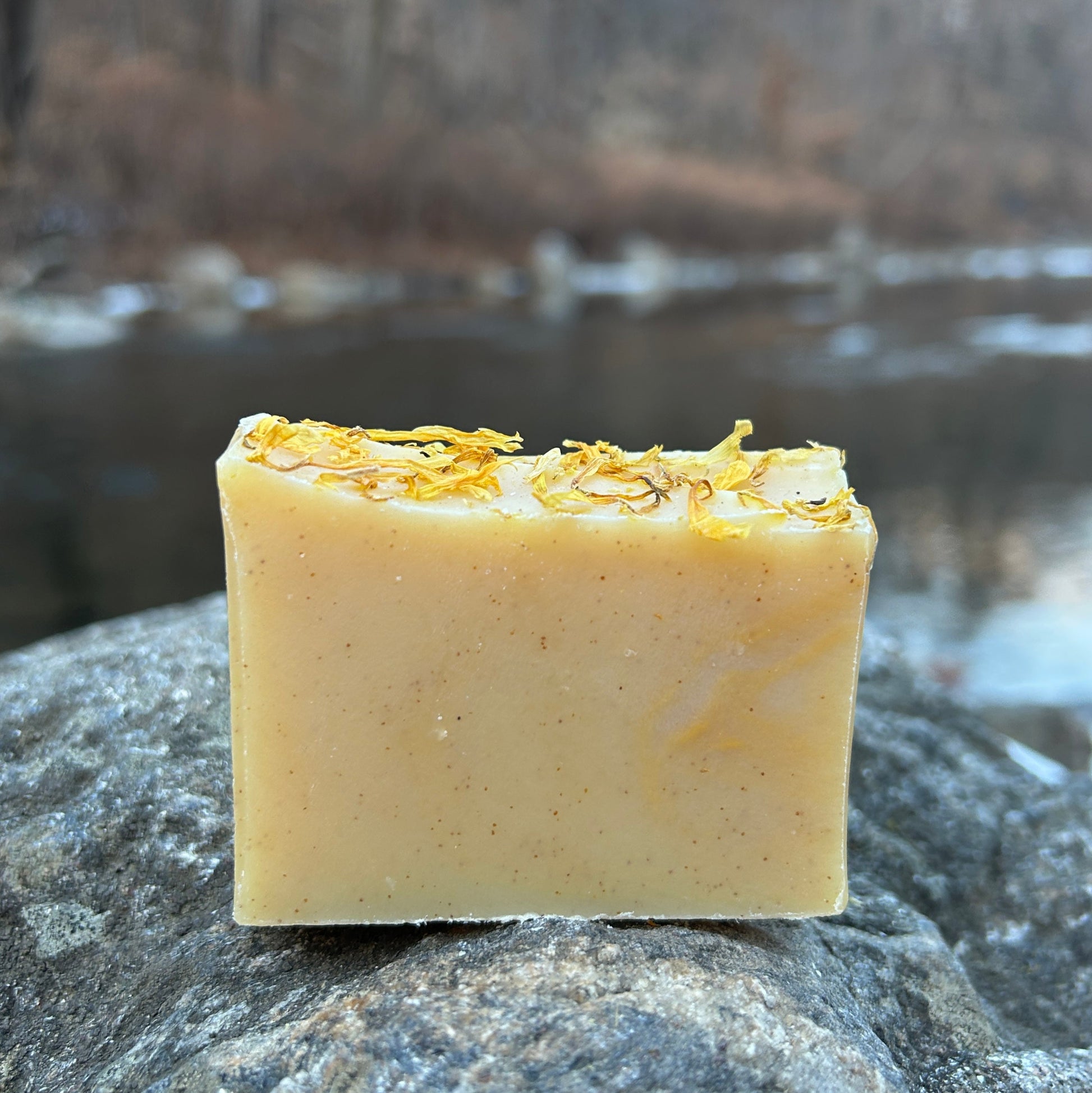 Handmade citrus and calendula soap bar infused with calendula flowers and scented with orange and lemon essential oils. Made with organic coconut oil, olive oil, shea butter, mango seed butter, and sunflower oil for a nourishing cleanse. Naturally colored with yellow clay and turmeric, with walnut shells for gentle exfoliation. Each bar weighs approximately 3 ounces and is wrapped in eco-friendly lokta paper.