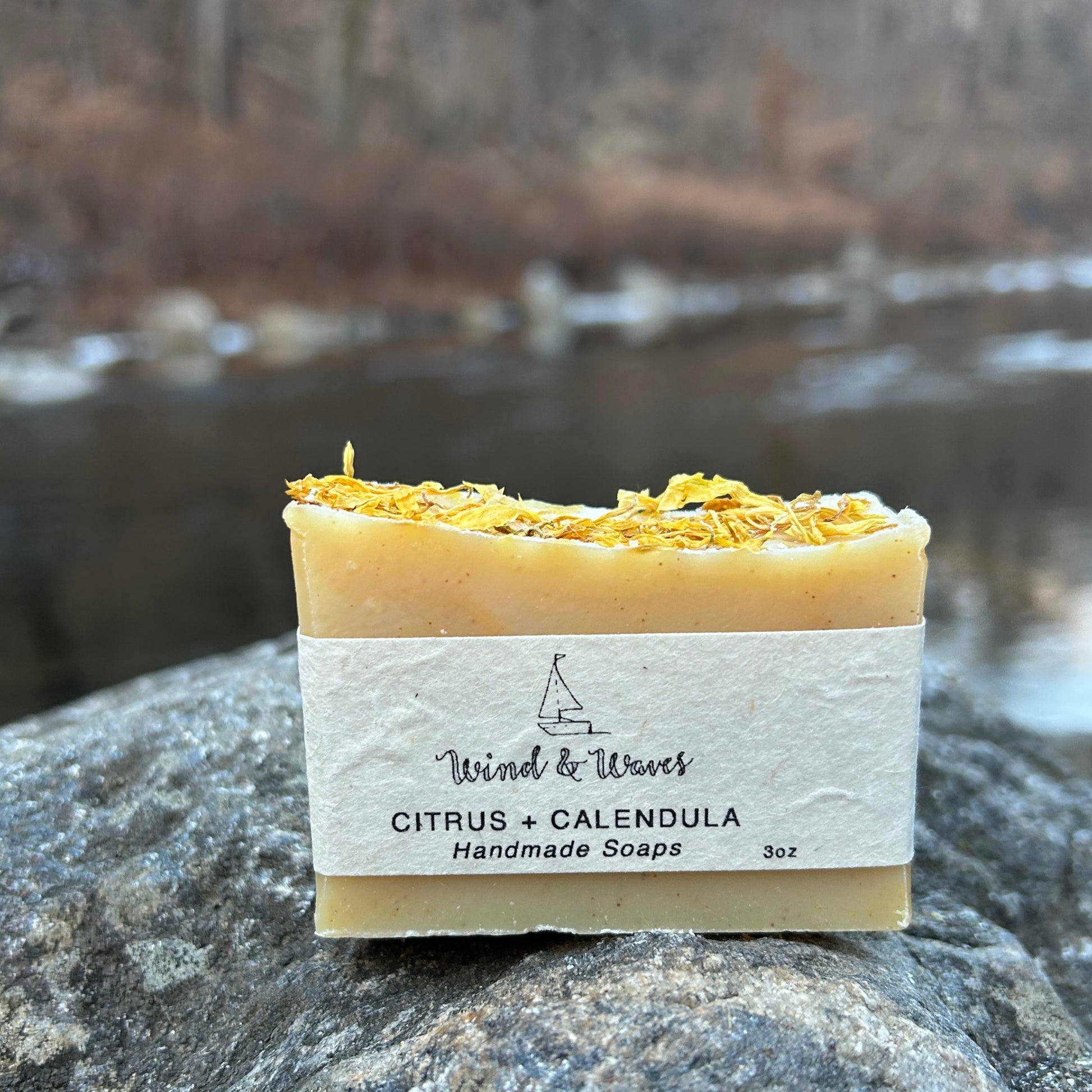 Handmade citrus and calendula soap bar infused with calendula flowers and scented with orange and lemon essential oils. Made with organic coconut oil, olive oil, shea butter, mango seed butter, and sunflower oil for a nourishing cleanse. Naturally colored with yellow clay and turmeric, with walnut shells for gentle exfoliation. Each bar weighs approximately 3 ounces and is wrapped in eco-friendly lokta paper.