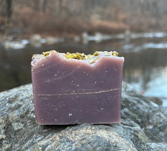 Handmade lavender and chamomile soap bar infused with calming chamomile flowers and scented with lavender essential oil. Made with organic coconut oil, olive oil, shea butter, and mango seed butter for a soothing and nourishing cleanse. Naturally colored with madder root and indigo powders, enhanced with kaolin clay. Each bar weighs approximately 3 ounces and is wrapped in eco-friendly lokta paper."