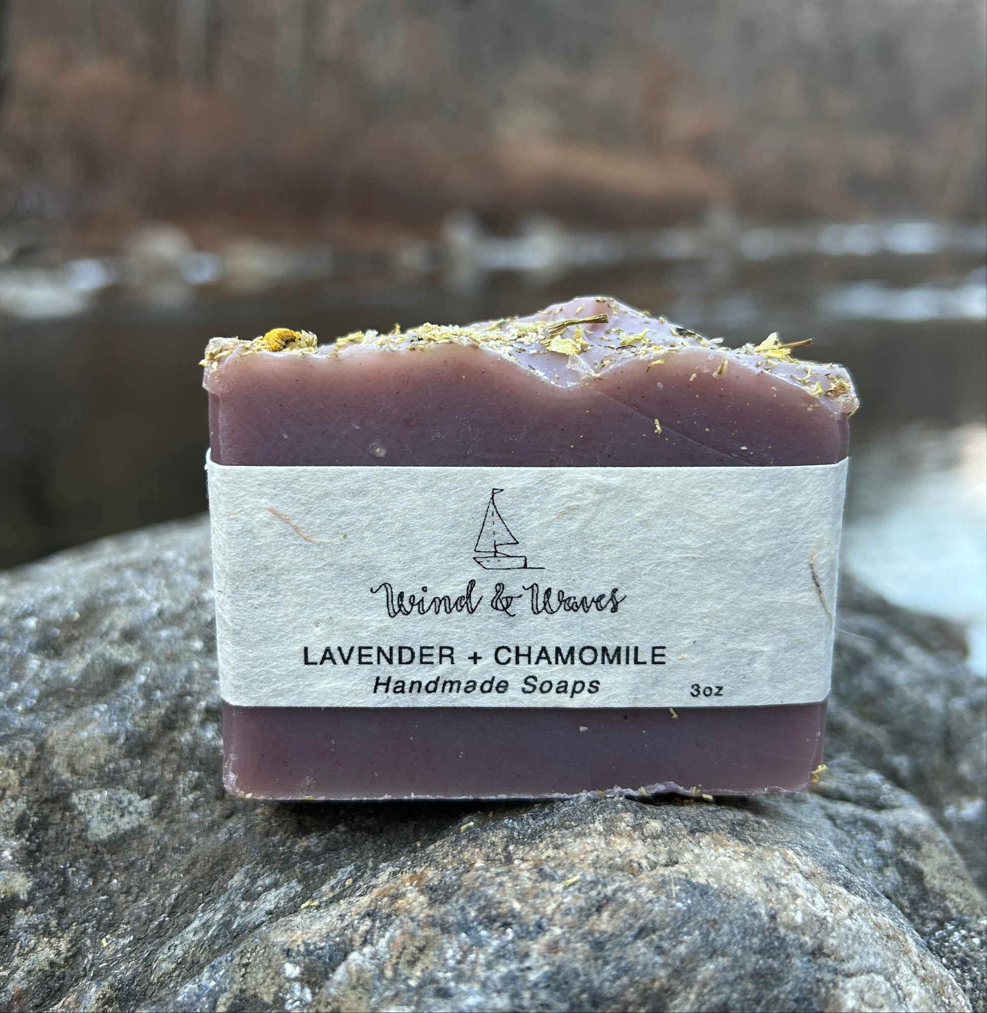 Handmade lavender and chamomile soap bar infused with calming chamomile flowers and scented with lavender essential oil. Made with organic coconut oil, olive oil, shea butter, and mango seed butter for a soothing and nourishing cleanse. Naturally colored with madder root and indigo powders, enhanced with kaolin clay. Each bar weighs approximately 3 ounces and is wrapped in eco-friendly lokta paper.