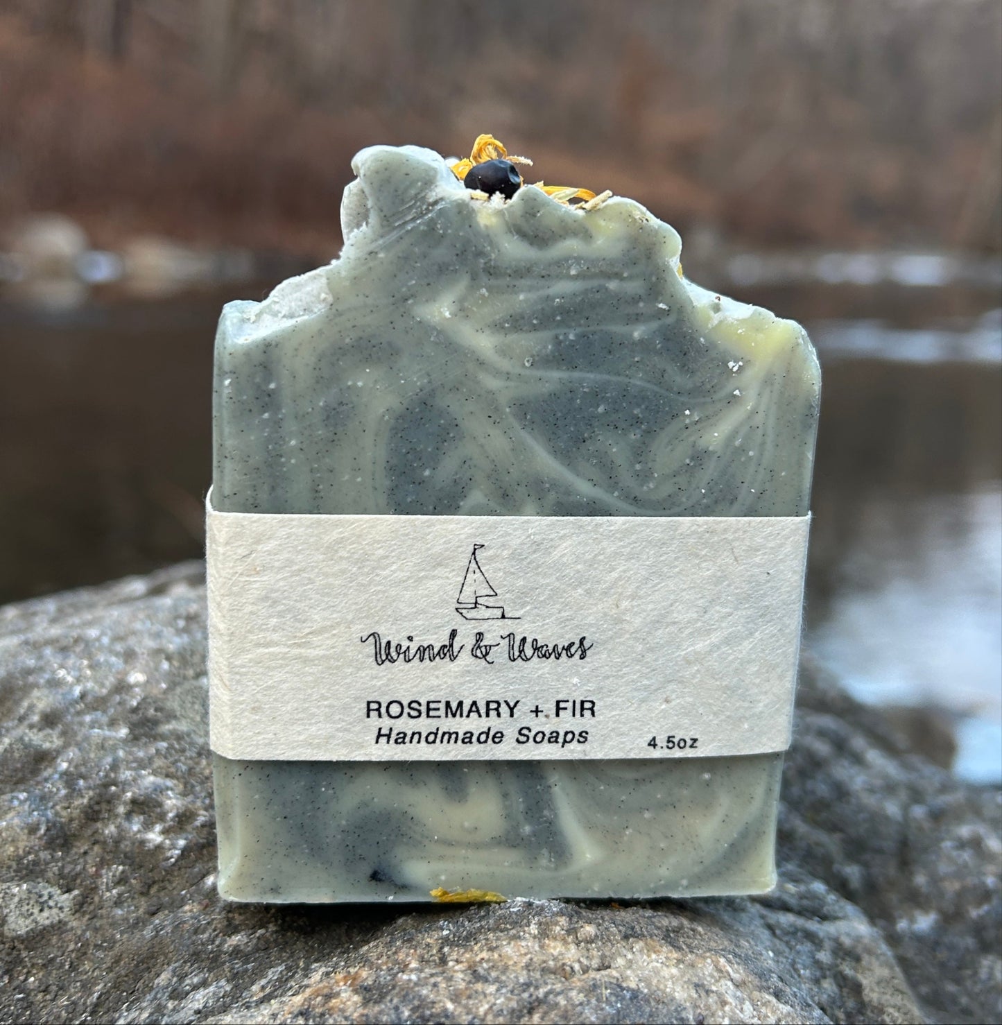 Handmade rosemary and fir soap bar infused with calendula tea, activated charcoal, and kaolin clay for a deep yet gentle cleanse. Crafted with organic coconut oil, olive oil, shea butter, and mango seed butter for nourishing care. Accented with calendula flowers and juniper berries, and scented with rosemary and fir essential oils for a fresh, woodsy aroma. Each bar weighs approximately 3 ounces and is wrapped in eco-friendly lokta paper.